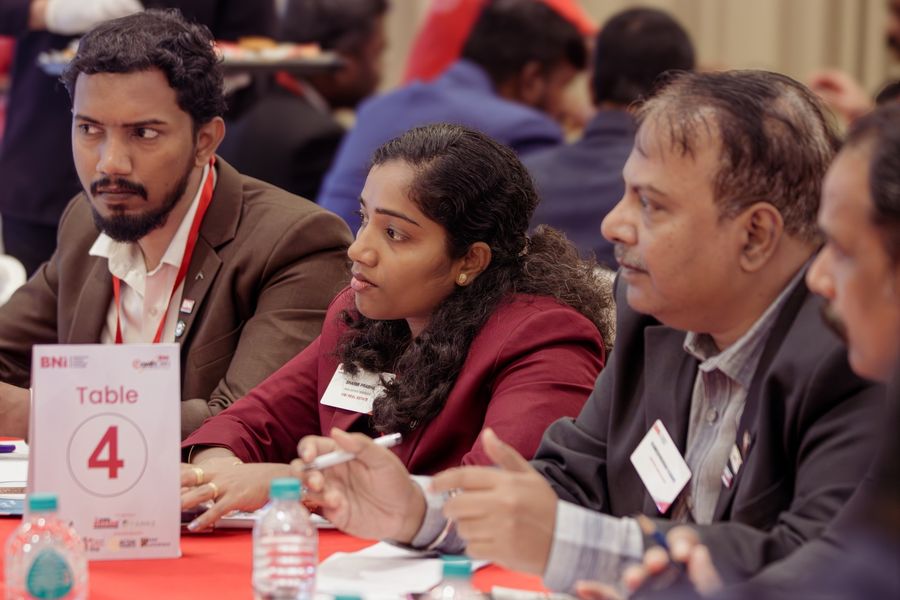 Members listening closely at Table 4 during a networking round