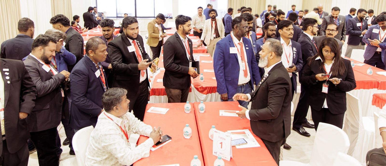 Open networking at the last GrowthCON: the hall full of members standing in conversation between red-clothed tables